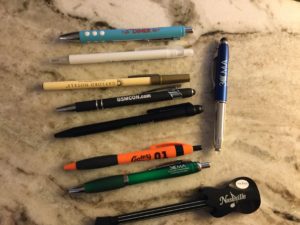 Eight different ink pens from various vendors from a conference.