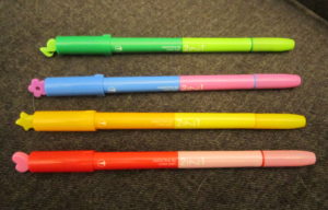 image of four pens and stamps of various shades of green, red, yellow, and blue