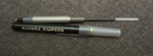 Metal pen uncapped with the grip unscrewed from the barrel.