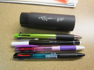 A tube with Korean on it and three multifunction pens and a marker