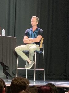 Neil Patrick Harris on a stool talking to audience
