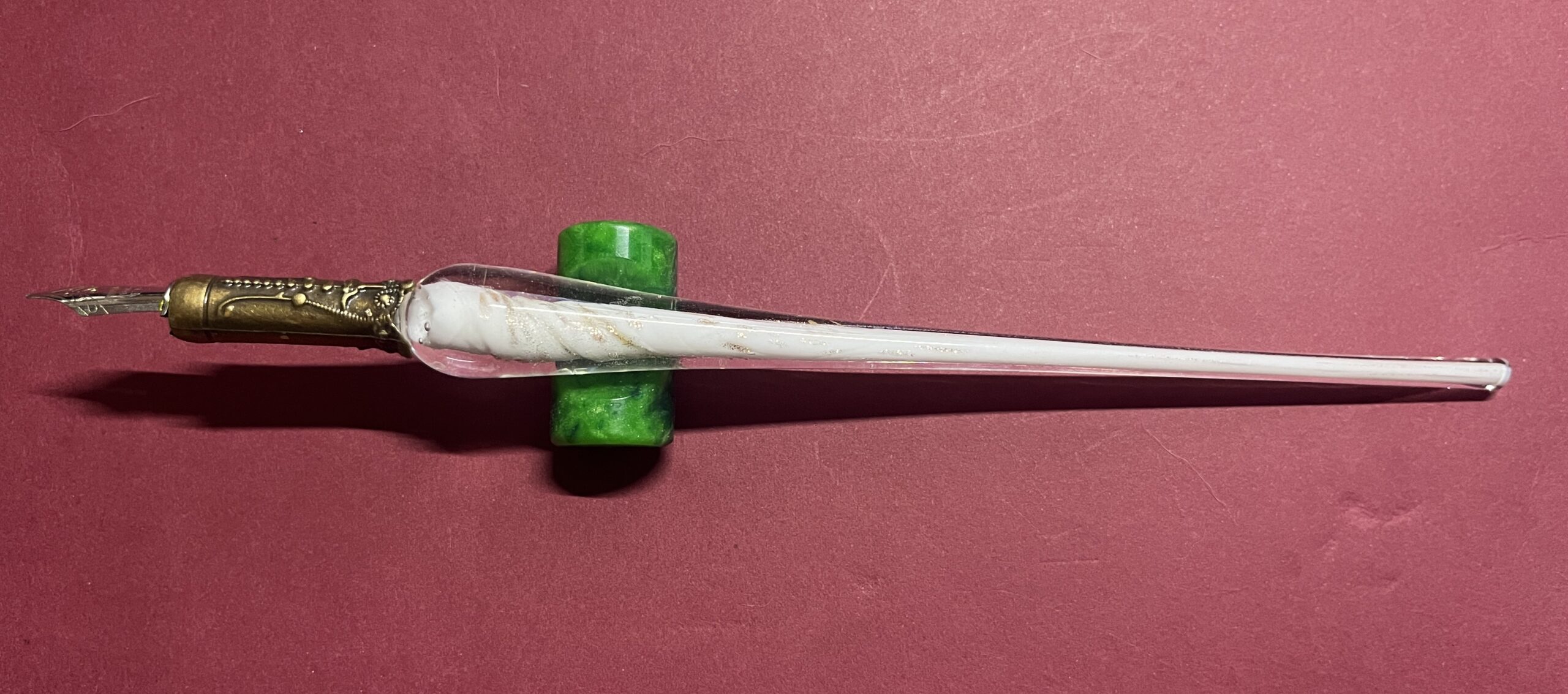 A white and gold dip pen with a bronze grip