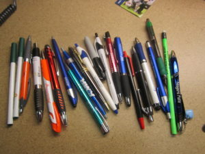 A collection of pens and pencils from various companies. 